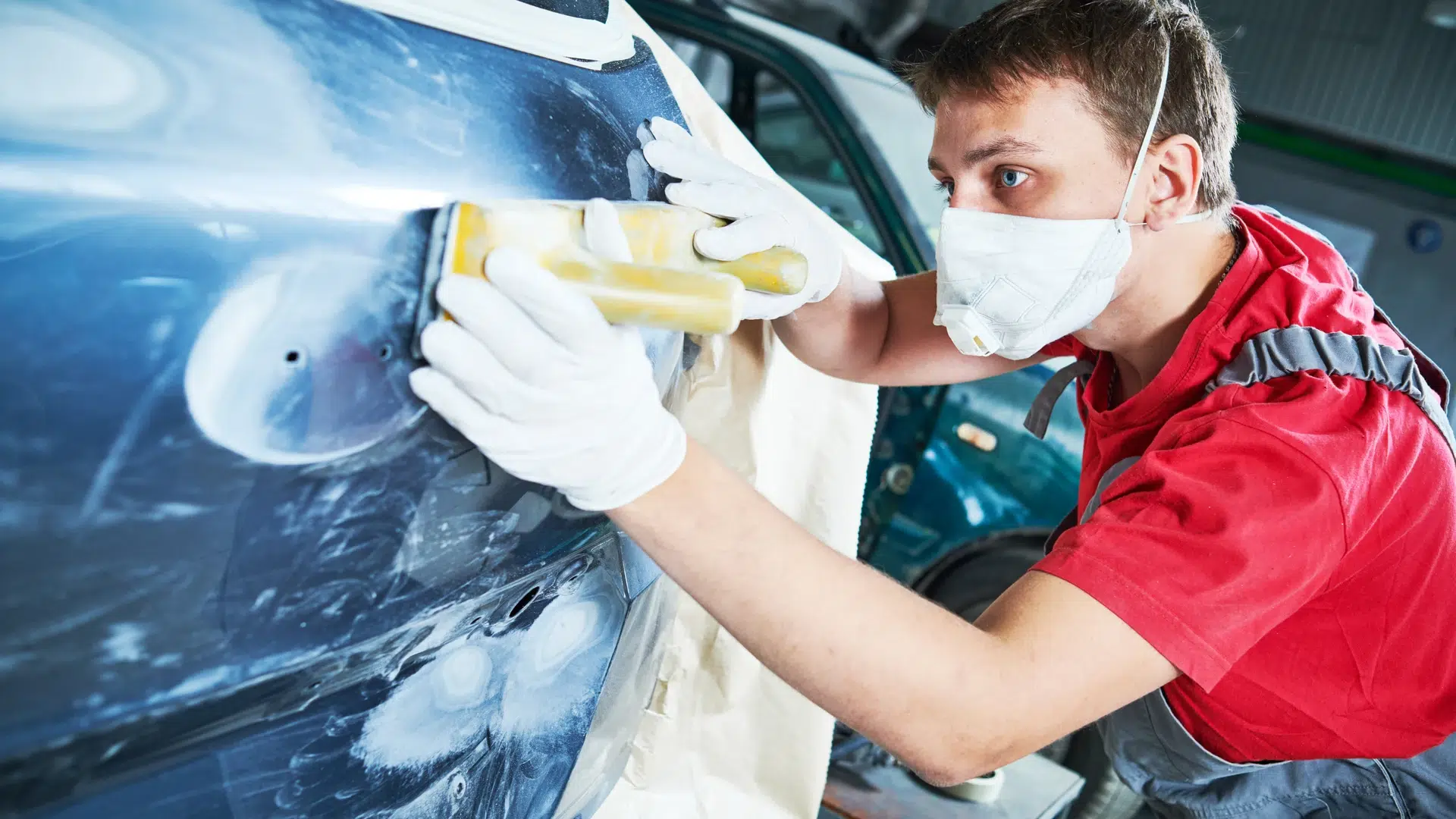 Homme ponçant une voiture